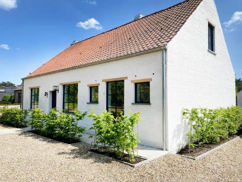 a white building with plants in front of it at Vakantiehuis Zand7 in Lommel