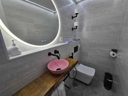 a bathroom with a pink sink and a mirror at Habitación Familiar in Madrid