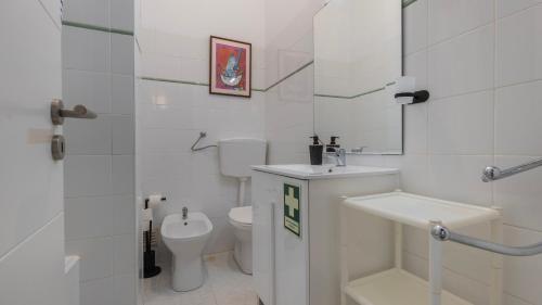 a white bathroom with a toilet and a sink at Seaside Getaway With Balcony by LovelyStay in Almada