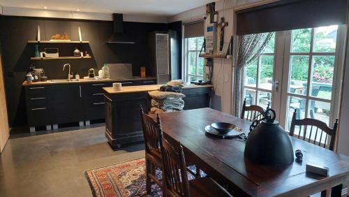 a kitchen with a wooden table and a kitchen with a sink at Kouwenberg in Aarle-Rixtel