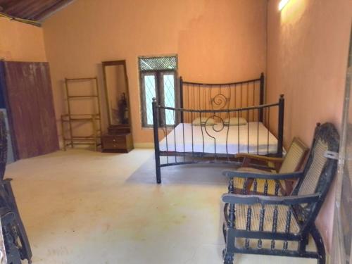 a bedroom with a bed and two chairs in it at Kit Cott Resort and Retreat in Teligama