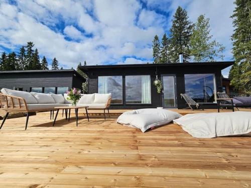 a patio with white pillows on a wooden floor at Skandinaavinen mökki rannalla in Vaala