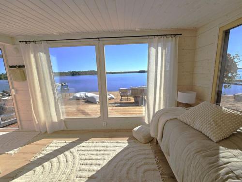 a bedroom with a large window with a view of the water at Skandinaavinen mökki rannalla in Vaala