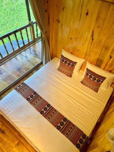 a bed in a room with a window at Muong Tra Stream Homestay in Làng Cac