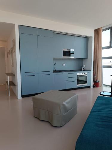 a living room with a large blue kitchen with a ottoman at Matteotti28 in Pesaro
