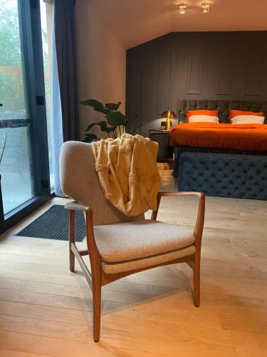 a bedroom with a chair with a blanket on it at De Zeeuwse Tobbe in 's-Heerenhoek