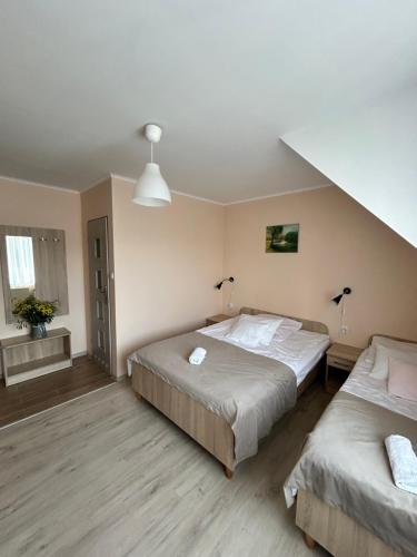 a bedroom with two beds and a staircase at Dom Gościnny Stokrotka in Pustkowo