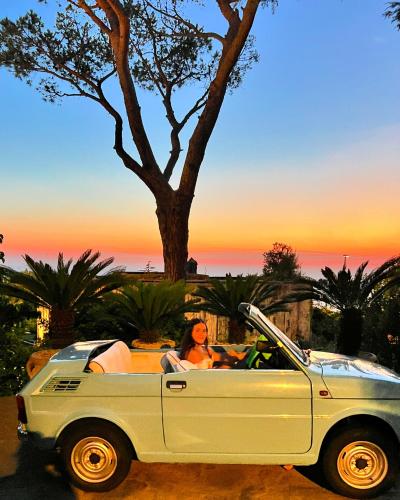 a woman sitting in the back of a white car at La Canostra Capri - luxury ROOM ad Anacapri in Anacapri