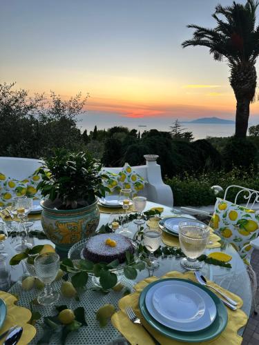 a table with blue and yellow plates and glasses on it at La Canostra Capri - luxury ROOM ad Anacapri in Anacapri