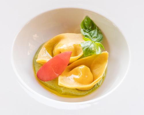 a bowl of food with oranges and greens on it at Relais CastelBigozzi in Monteriggioni