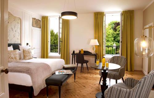 GuéronにあるChâteau Saint Gilles - Bayeuxのベッドルーム1室(ベッド1台、テーブル、椅子付)