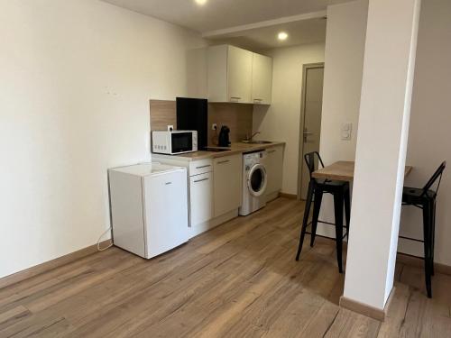 une petite cuisine avec un micro-ondes et une table dans l'établissement Appartement avec exterieur, à Le Soler