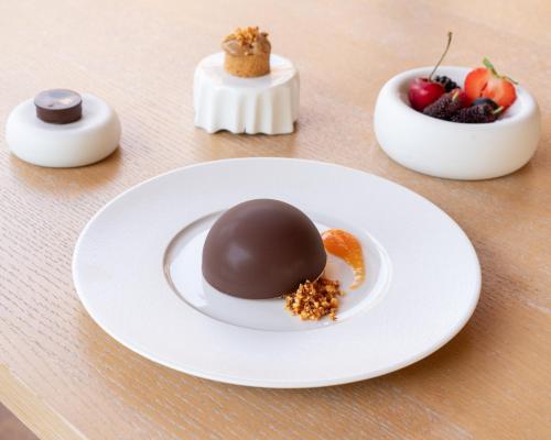 a chocolate dessert on a white plate with fruit at Relais CastelBigozzi in Monteriggioni