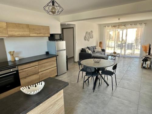 une cuisine et un salon avec une table et des chaises dans l'établissement Guedins'House, à Bonifacio