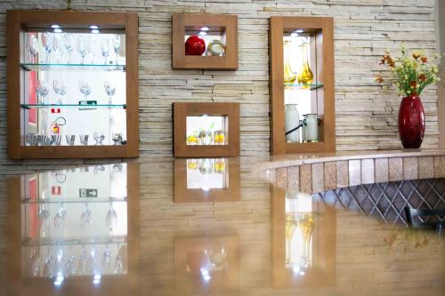 a wall of wine glasses in a room at Presidente Hotel in Poços de Caldas
