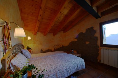 a bedroom with a bed and a window at Lo Paller de Roc in Montescladó