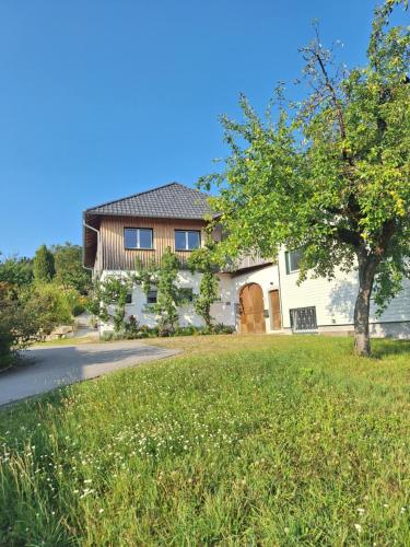 una casa con un árbol delante de un patio en Gut Pecketsberg, en Oepping