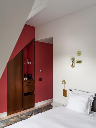 a bedroom with a red accent wall and a bed at Parc Broekhuizen l Culinair landgoed in Leersum