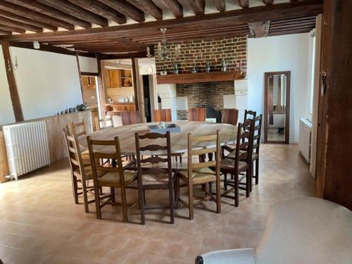 une salle à manger avec une grande table et des chaises en bois dans l'établissement Gite au cœur des pâturages, à Le Pré-dʼAuge