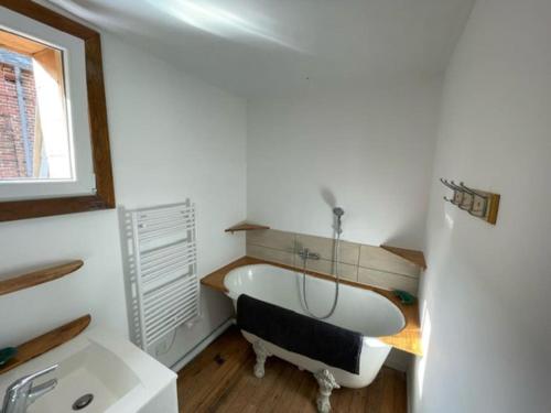 une salle de bain avec baignoire dans une chambre dans l'établissement Gite au cœur des pâturages, à Le Pré-dʼAuge