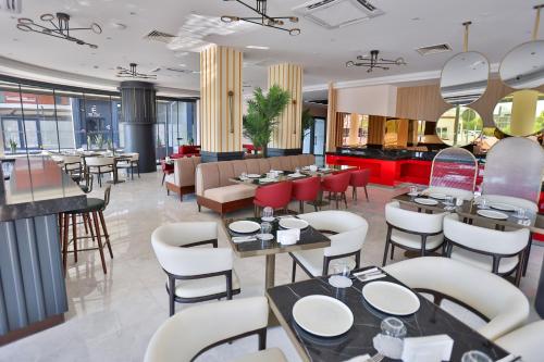 a restaurant with tables and chairs in a room at Caddem Inn Hotel in Mağusa