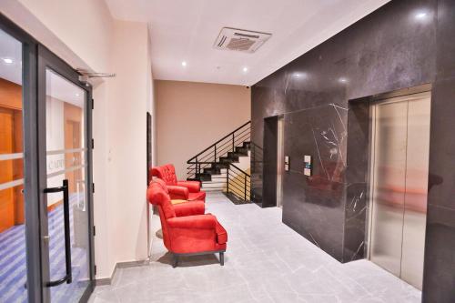 a living room with a red chair and stairs at Caddem Inn Hotel in Mağusa