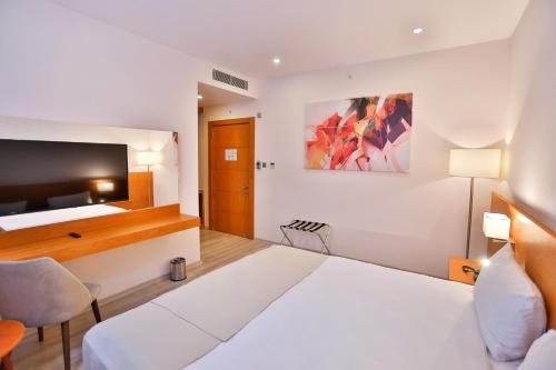 a hotel room with a bed and a tv at Caddem Inn Hotel in Mağusa