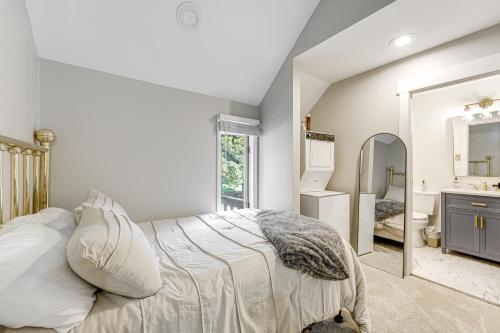 a white bedroom with a bed and a mirror at Ellicottville Townhome Near Holiday Valley Resort! in Ellicottville