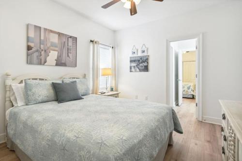 a white bedroom with a bed and a ceiling fan at Biloxi Waterfront House View of Bayou with fishing in Biloxi