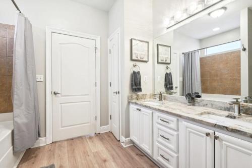 a bathroom with two sinks and a large mirror at Biloxi Waterfront House View of Bayou with fishing in Biloxi