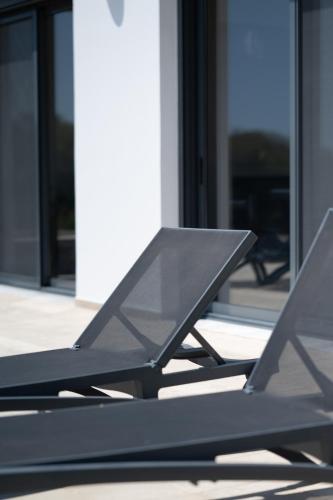 a black picnic table in front of a building at Villa & Stone House with Pool, 10 Mins to Skala Eressos Beach in Eresos