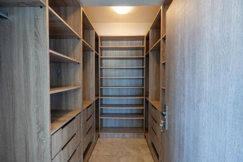 a walk in closet with wooden shelves at Villa & Stone House with Pool, 10 Mins to Skala Eressos Beach in Eresos