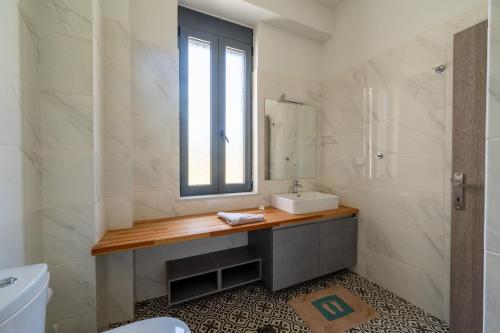 a bathroom with a sink and a mirror at Villa & Stone House with Pool, 10 Mins to Skala Eressos Beach in Eresos