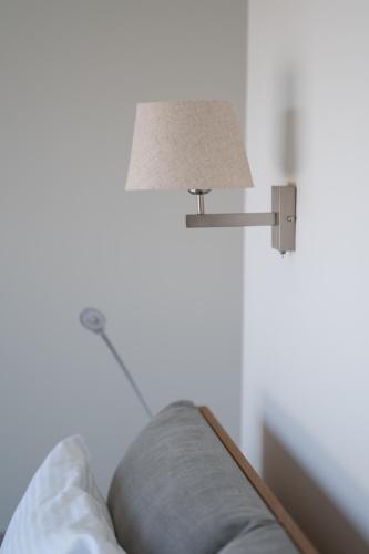 a lamp sitting on a wall next to a couch at Villa & Stone House with Pool, 10 Mins to Skala Eressos Beach in Eresos