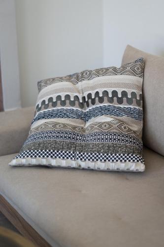 a pillow sitting on top of a couch at Villa & Stone House with Pool, 10 Mins to Skala Eressos Beach in Eresos