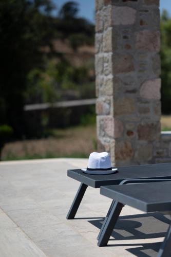 a hat sitting on top of a picnic table at Villa & Stone House with Pool, 10 Mins to Skala Eressos Beach in Eresos