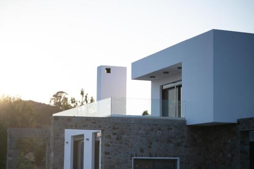 a modern house with a blue facade at Villa & Stone House with Pool, 10 Mins to Skala Eressos Beach in Eresos