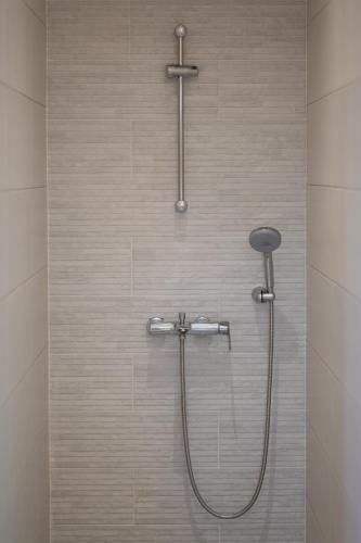 a shower with a shower head in a bathroom at Villa & Stone House with Pool, 10 Mins to Skala Eressos Beach in Eresos