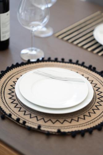 a white plate on a table with a glass at Villa & Stone House with Pool, 10 Mins to Skala Eressos Beach in Eresos