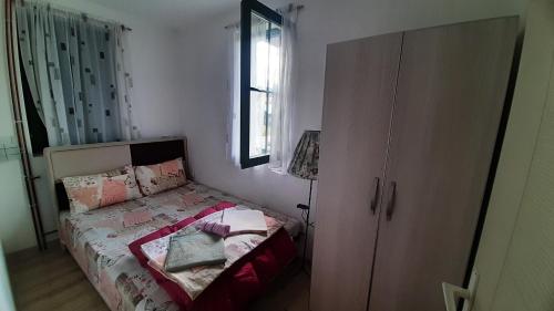 a small bedroom with a bed and a dresser at Apartments Durmitor in Žabljak