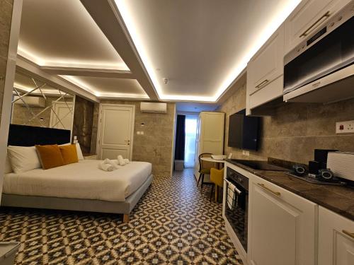 a small hotel room with a bed and a kitchen at Balcony Hotel in St Julian's