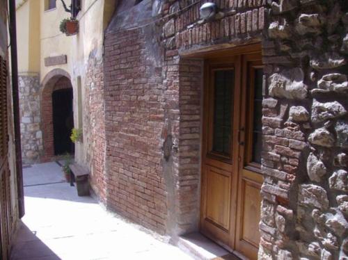 a brick building with a wooden door on it at GAVORRANO - Ravi appartamento indipendente in Ravi