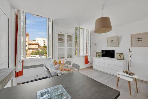 un salon avec une table et une grande fenêtre dans l'établissement Aurore - T1 12, à Carcassonne