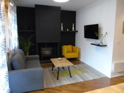 a living room with a couch and a yellow chair at Appartamento Nicole in Ravascletto