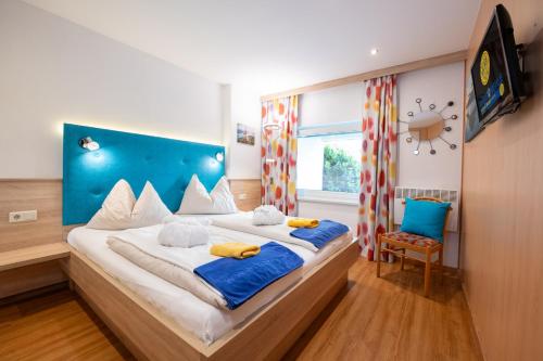 a bedroom with a large bed with a blue headboard at Barry Memle Directly at the Lake in Velden am Wörthersee