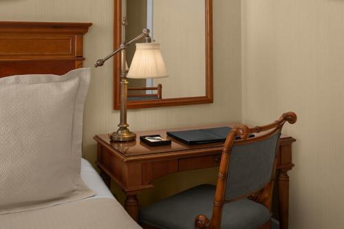 a bedroom with a desk with a lamp and a bed at Capital Hotel in Little Rock