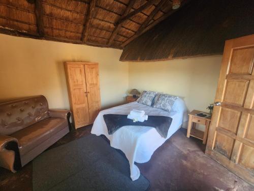 Un dormitorio con una cama, un sofá y una mesa. en Reedbuck Lodge, en Amsterdam