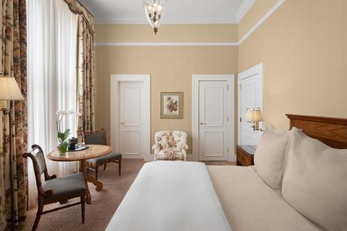a bedroom with a bed and a table and a chair at Capital Hotel in Little Rock