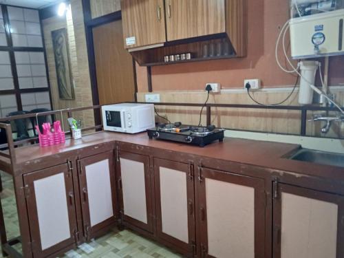 a kitchen with a counter with a microwave on it at Oxygen Homestay-A Blissful Retreat in Dehradun