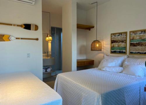a bedroom with a bed with a white comforter at Flô Casa Hotel in Trancoso